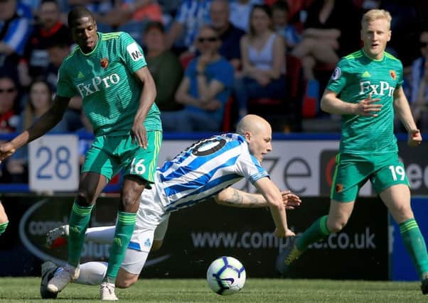 Huddersfiled Town's Aaron Mooy is tackled by Watford's Abdoulaye Doucoure at the John Smith's Stadium. Picture: Clint Hughes/PA