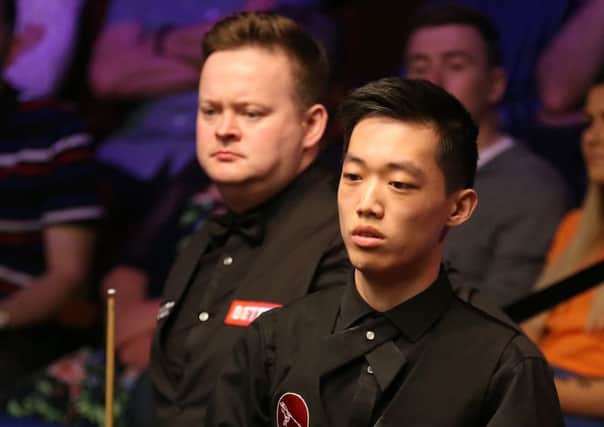 Record exit: Luo Honghao, right, falling to Shaun Murphy at The Crucible.