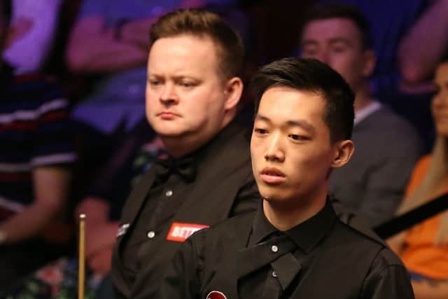 Record exit: Luo Honghao, right, falling to Shaun Murphy at The Crucible.