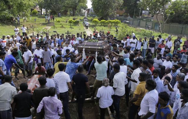 Sri Lankans prepare to bury the coffins carrying remains of Berington Joseph, left, and Burlington Bevon, who were killed in the Easter Sunday bombings in Colombo, Sri Lanka (AP Photo/Eranga Jayawardena)