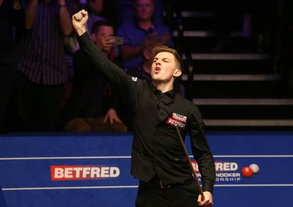 James Cahill celebrates after beating Ronnie O'Sullivan 10-8 at The Crucible. Picture: Nigel French/PA