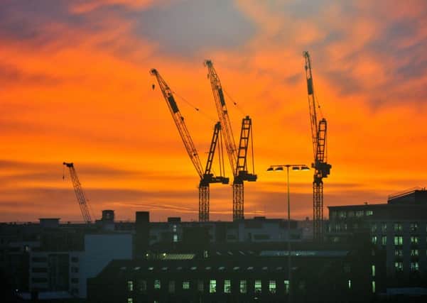 Work cranes silhouetted against a spectacular sunrise in the centre of Leeds. Picture Gerard Binks