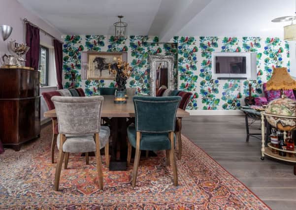 The dining room with Osborne and Little wallpaper and a bespoke 12-seater dining table with chairs from Redbrick Mill, Batley