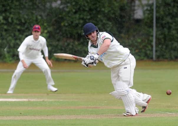 In the runs: Steve Bullen clips the ball away for New Farnley as the rain comes down in a game against Woodlands that was eventually abandoned