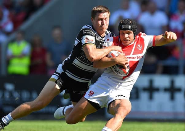 St Helens' Jonny Lomax  is tackled by Hull FC's Jamie Shaul.