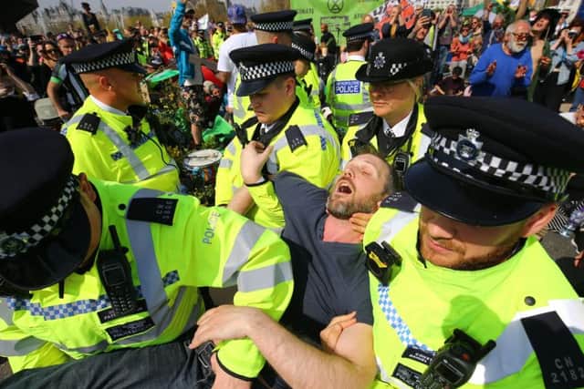 Police remove an Extinction Rebellion demonstrator from London's Waterloo Bridge.