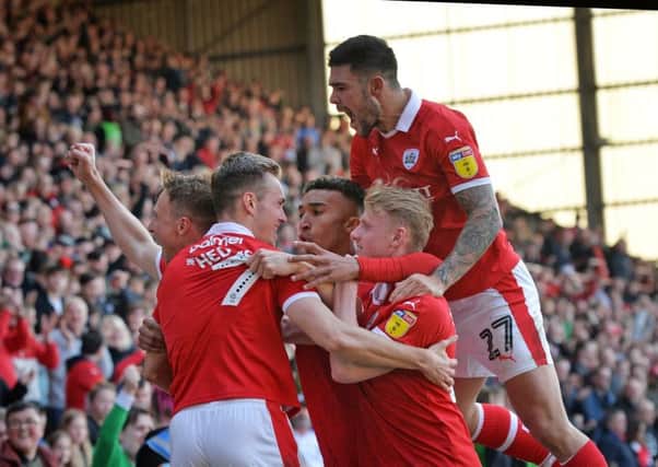 Band of brothers: Cauley Woodrow and company celebrate his goal for Barnsley against Coventry City.
