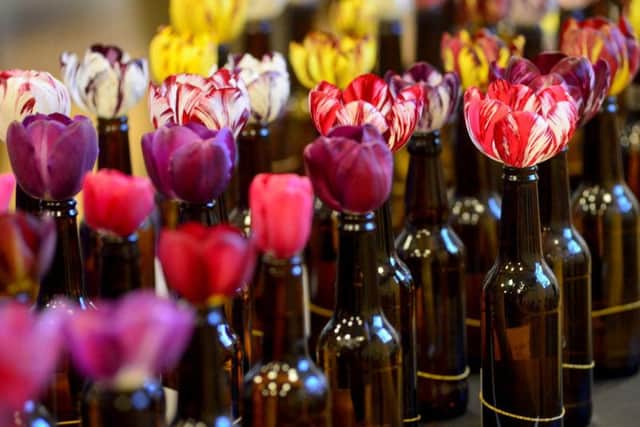 In a long-standing tradition, the flowers are displayed in beer bottles.
