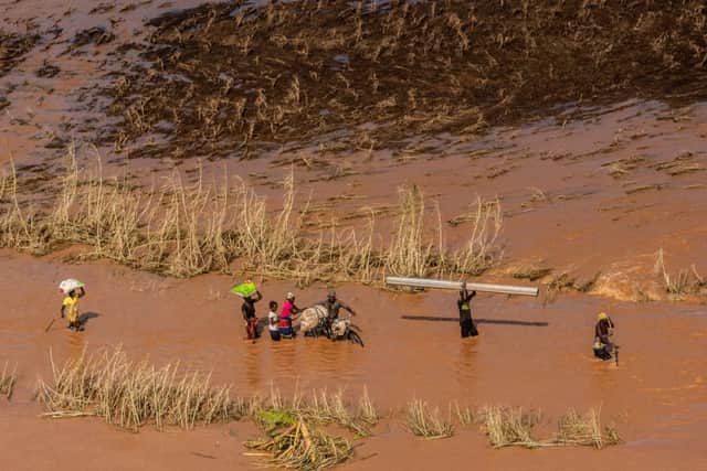 People wade through flood waters in a rural neighborhood affected by Cyclone Idai on March 24, 2019 in Buzi, Mozambique. Photo by Andrew Renneisen/Getty Images