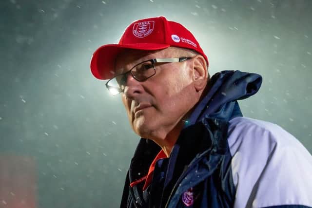 Hull KR coach Tim Sheens walks the ground under the snow prior to the match.
