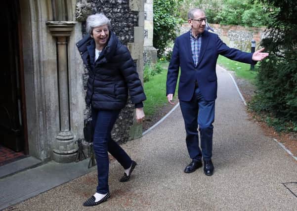 Theresa May arrives at church yesterday with her husband Philip.
