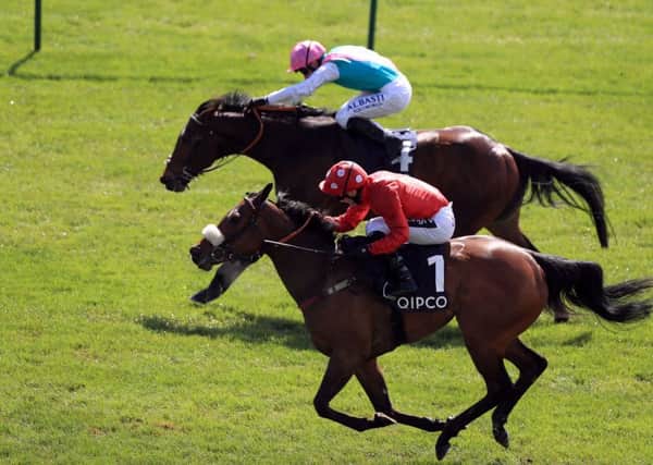 Mabs Cross ridden by jockey Paul Mulrennan (no.1) wins the Zoustar Palace House Stakes ahead of Equilateral ridden by Oisin Murphy (top) at Newmarket.