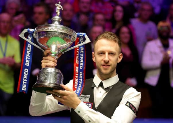 Judd Trump celebrates with the trophy.