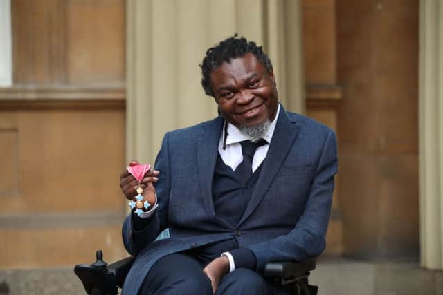 Yinka Shonibare holds his CBE for services to art following an investiture ceremony at Buckingham Palace