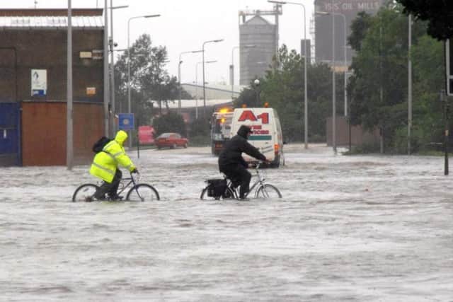 People cycling through water on Cleveland Street in Hull, after the floods of 2007, which brought devastation to the city and Sheffield and left three people dead