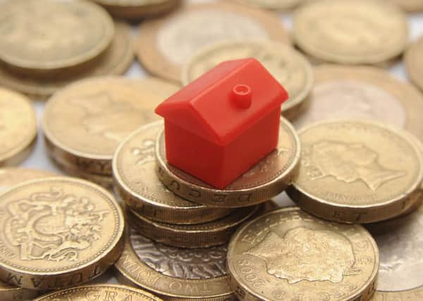 File photo dated 27/01/15 of a plastic model of a house on a pile of one pound coins Photo credit should read: Joe Giddens/PA Wire