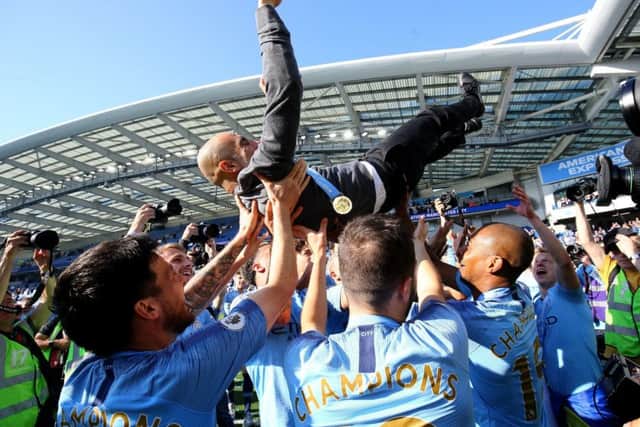 Manchester City manager Pep Guardiola is lifted up by his players at the AMEX Stadium. Picture: Gareth Fuller/PA