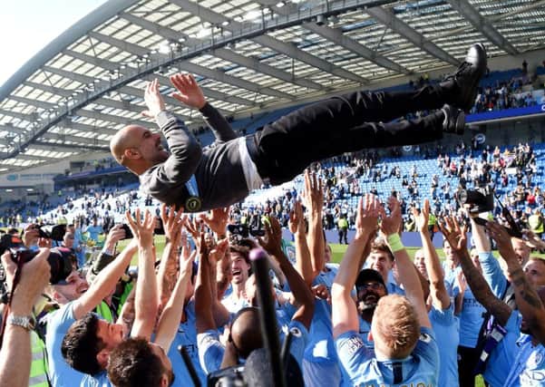 HIGH TIMES: Manchester City players throw manager Pep Guardiola into the air as they celebrate winning the Premier League title Picture: Mike Hewitt/Getty Images.