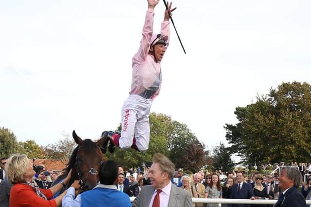 Andrew Lloyd Webber and his wife Madeline look on after Frankie Dettori celebrates Too Darn Hot's win in the Dewhurst Stakes at Newmarket with a flying dismount.