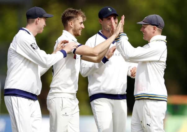 Ben Coad (2nd L) of Yorkshire enjoys a high five with Gary Ballance after taking the wicket of Ollie Robinson.