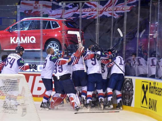 Great Britain's players mob goalscorer Ben Davies (hidden) after his overtime goal ensured they would remain in the top tier of the world championship. Picture: Dean Woolley