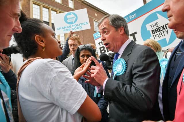 Brexit Party leader Nigel Farage has a political discussion with a woman during the campaign trail in Exeter, ahead of today's European elections. Picture: Ben Birchall/PA Wire