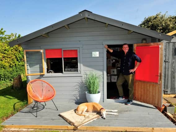 Andy outside 'The Garden Shed' with dog Toby.