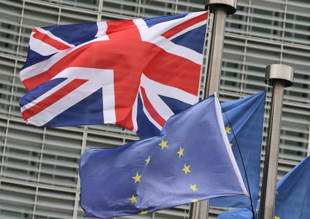 This photo taken on December 8, 2017 at the European Commission in Brussels shows the British national flag raised on a flagpole next to flags of the European Union. 
Britain and the EU reached a historic deal on December 8 on the terms of the Brexit divorce after the British Prime Minister rushed to Brussels for early morning talks.  / AFP PHOTO / EMMANUEL DUNAND        (Photo credit should read EMMANUEL DUNAND/AFP/Getty Images)