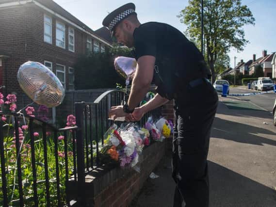 Police with the flowers and tributes left in Shiregreen