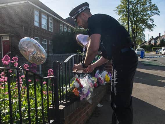 Police with flowers left in the street in Sheffield