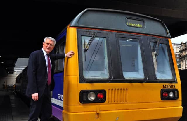 Rail Minister Andrew Jones at Leeds station with a Pacer train.