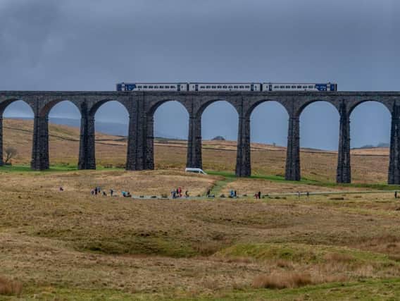 A Northern train passes over Ribblehead Viaduct
