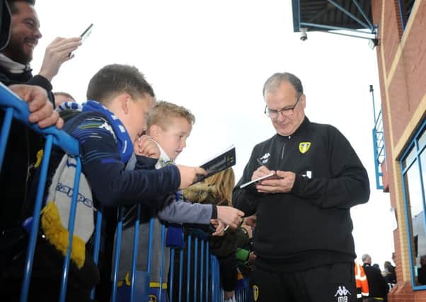 Marcelo Bielsa signs autographs for adoring fans who will be delighted, as will all Leeds United supporters, that he is remaining as head coach at Elland Road (Picture: Tony Johnson).