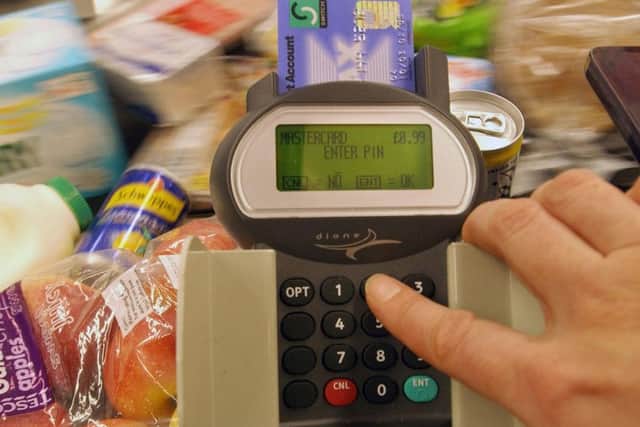 A shopper in Tesco's West Cromwell Road supermarket  purchases shopping on 29th December 2004, the day that debit and credit cards overtake cash as a means of payment in Britain See PA Story CONSUMER Plastic;. PRESS ASSOCIATION Photo.  Photo credit should read Fiona Hanson/PA