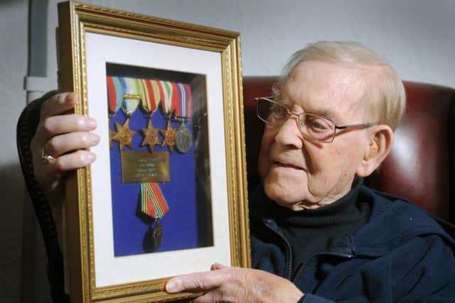 D Day veteran Leslie Harry Postill, from Whinmoor, Leeds looks at some of his military medals. Picture Tony Johnson.