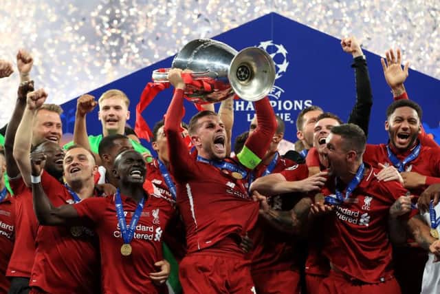 Liverpool's Jordan Henderson lifts the trophy with his team-mates in Madrid. Picture: Peter Byrne/PA