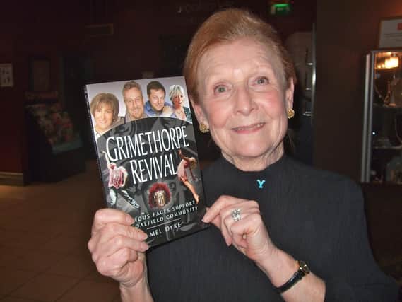 Author Mel Dyke, now an MBE, with one of her books.