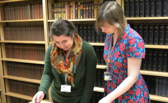 Archivists Lydia Dean and Sally-Anne Shearn with the forces canteen visitor book.