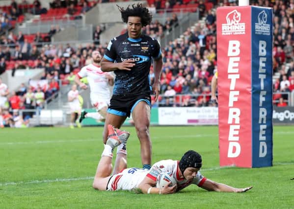 St Helens Saints' Jonny Lomax goes over for his second try past Huddersfield Giants' Dom Young.