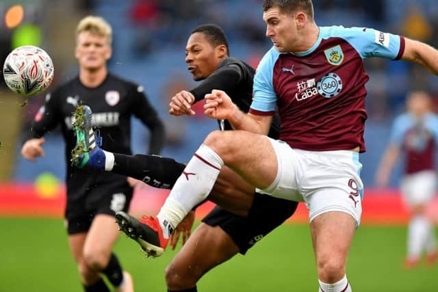 Barnsley's Ethan Pinnock (left) and Burnley's Sam Vokes (right) battle for the ball in the FA Cup, third round match at Turf Moor. Picture: Dave Howarth/PA