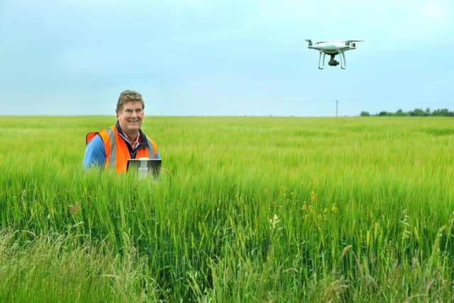 Richard Dee a drone operator flying  his drone over a field of winter barley near to Hornsea.