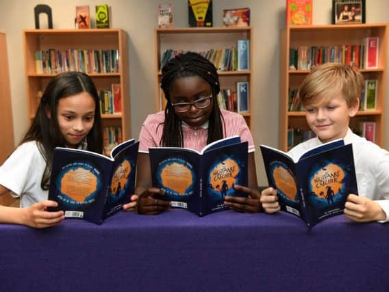 Beeston Primary pupils with first copies of the illustrated book The Nightmare Catcher, they helped write with Leeds Beckett. Pictured (from left) Zahraa Ahmed, Liz Usseni and Lucas Harker.