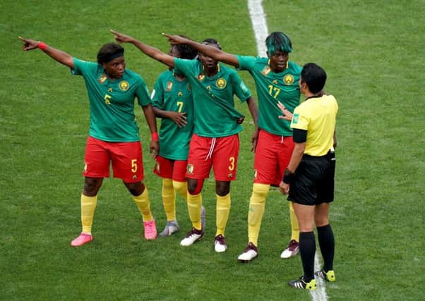 Cameroon's Augustine Ejangue (left to right), Gabrielle Aboudi Onguene (second left), Ajara Nchout (centre) and Gaelle Enganamouit (second right) appeal to match referee Qin Liang (right) after England's second goal was given by VAR after an offside call.
