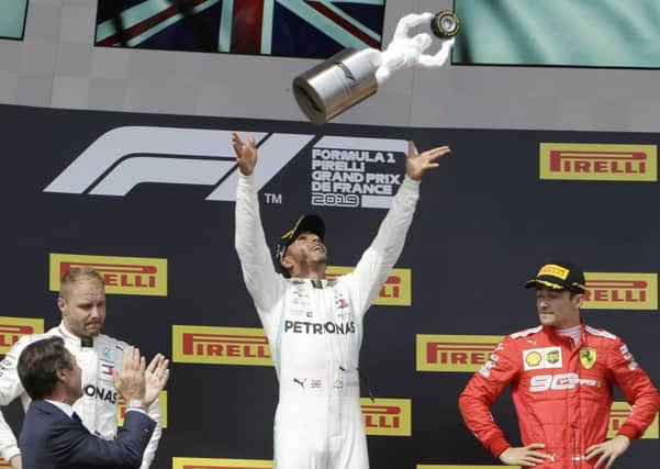 Mercedes driver Lewis Hamilton, center, of Britain, celebrates on the podium Picture: AP/PA.