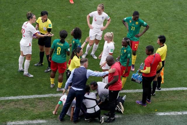 Match referee Qin Liang (second left) intervenes after Cameroon's Alexandra Takounda (21) fouls England's Steph Houghton (obscured) and England head coach Phil Neville (bottom left) and Cameroon head coach Alain Djeumfa (bottom right) exchange words during the FIFA Women's World Cup, round of Sixteen match at State du Hainaut, Valenciennes. (Picture: John Walton/PA Wire)