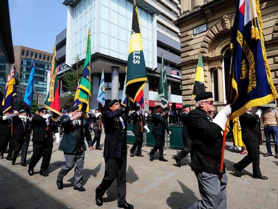 Flag bearers march down Commercial Street in Leeds city centre.