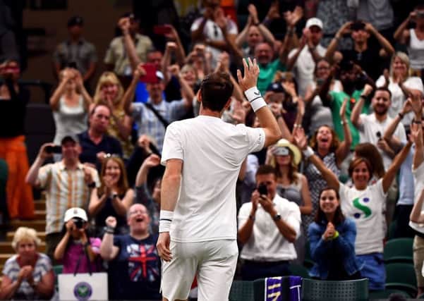 Andy Murray celebrates in front of the fans after winning his doubles match.