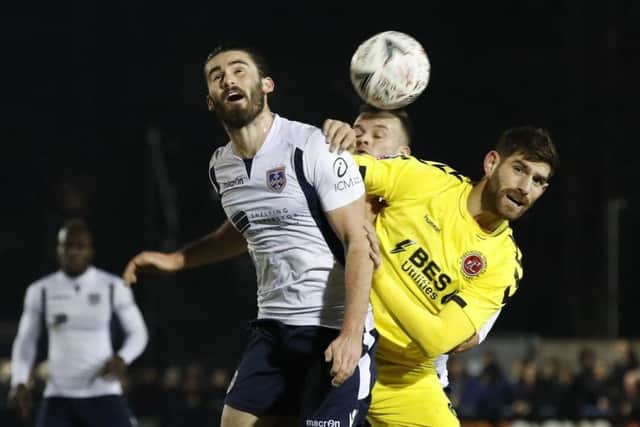 Guiseley's Alex Purver and Fleetwood Town's Ched Evans (right) battle for the ball during The Emirates FA Cup second round match at Nethermoor Park, Guiseley. (Picture: PA)