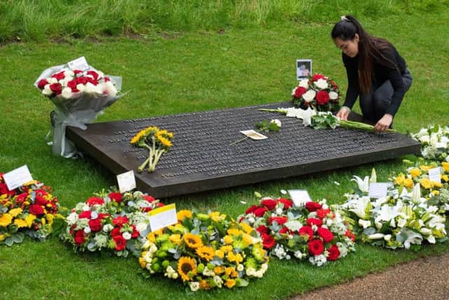 A woman lays flowers at the 7/7 Memorial, in Hyde Park, London, to mark the anniversary of the terrorist attacks on London on July 7 2005 that killed 52 people.