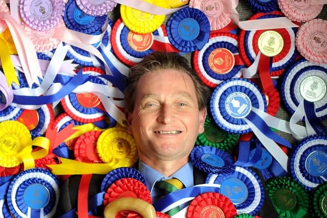 Yorkshire Agricultural Society chief executive Nigel Pulling surrounded by Great Yorkshire Show rosettes.